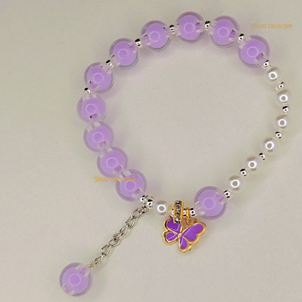 Purple beaded bracelet with a butterfly charm on a light gray background